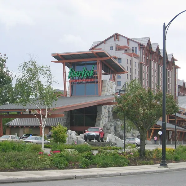 Le River Rock Casino Resort vu de River Road, avec sa façade de style chalet et la tour de l'hôtel derrière